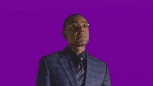a man in a suit and tie is being shot in the face by a gun