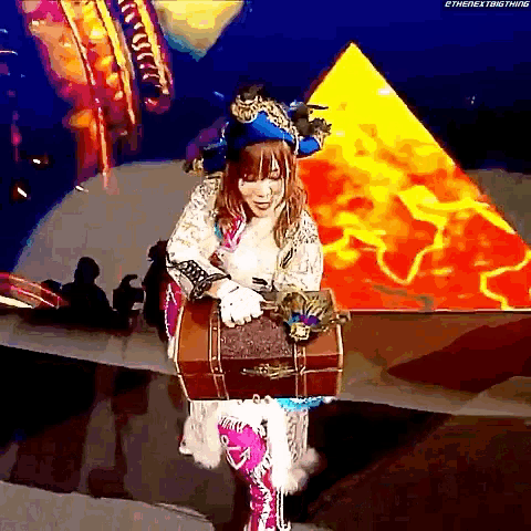 a woman in a pirate costume is holding a suitcase in front of a pyramid .