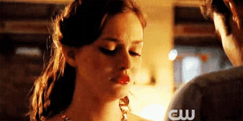 a close up of a woman 's face with the cw logo in the background