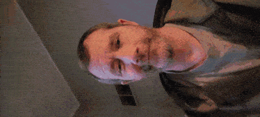 a man with a beard is standing in front of a blue light