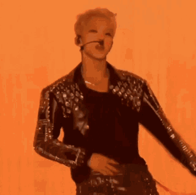 a man without a shirt is dancing on a stage with a microphone .