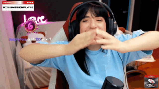 a woman wearing headphones is sitting in front of a screen that says missmaddenplays on it