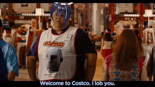 a man wearing a costco apron stands in a crowded store