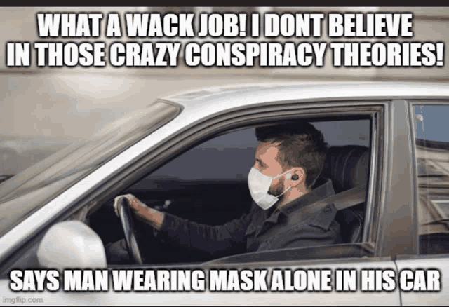 a man wearing a face mask driving a car