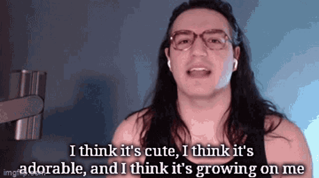 a man with long hair and glasses says i think it 's cute , i think it 's adorable