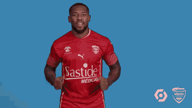 a man in a red bastide medical jersey points upwards