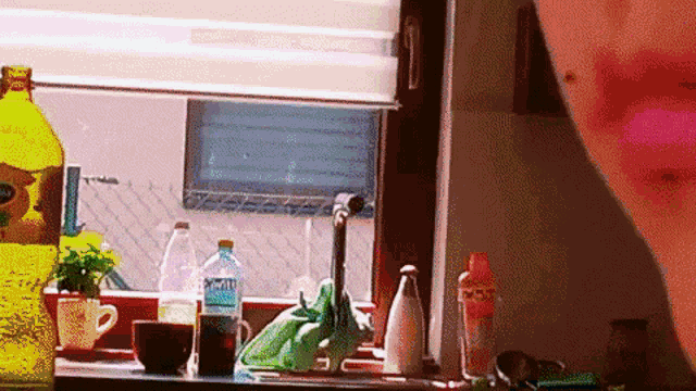 a bottle of sprite sits on a kitchen counter next to a window