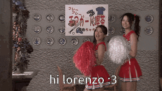 two cheerleaders hold pom poms in front of a sign that says hi lorenzo