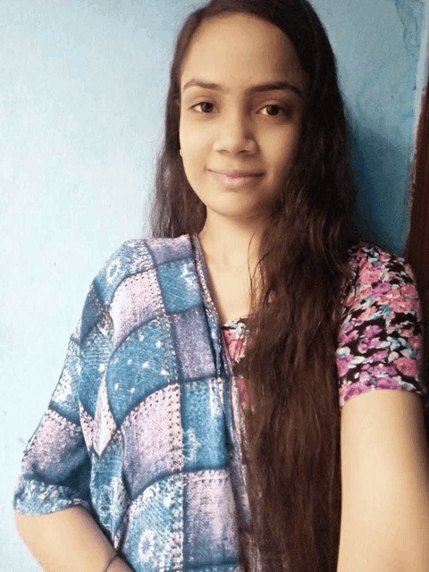 a woman with long hair wearing a blue and purple shirt