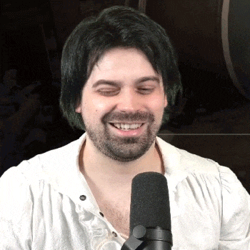 a man with green hair and a beard is smiling into a microphone