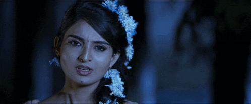 a woman with a flower in her hair looks very sad
