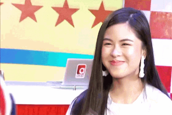 a woman is smiling in front of a laptop with the letter o on it .