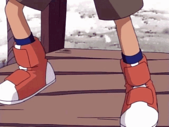 a close up of a person 's feet wearing red boots