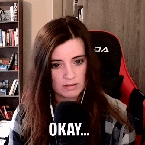 a woman wearing headphones and a red gaming chair says okay