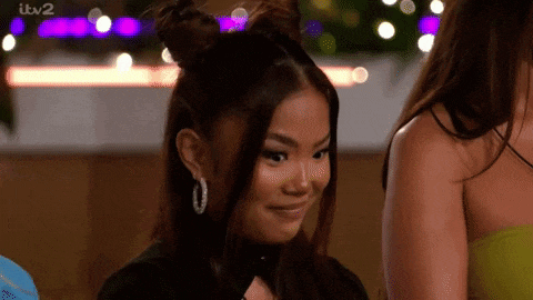 a woman with two buns in her hair is smiling while standing next to another woman .