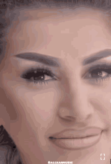 a close up of a woman 's face with the word balkanmusic written on the bottom right