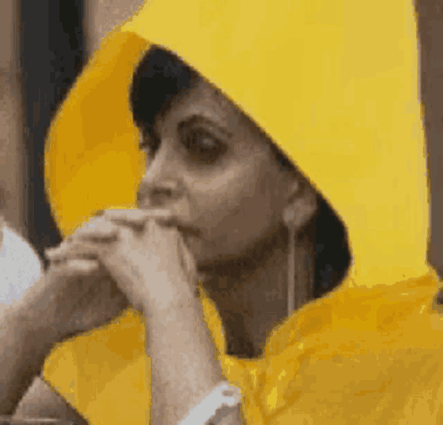 a woman wearing a yellow raincoat with a hood and ear buds
