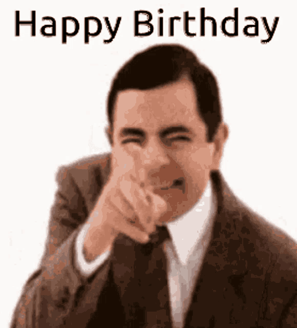 mr bean is pointing at the camera and saying happy birthday .