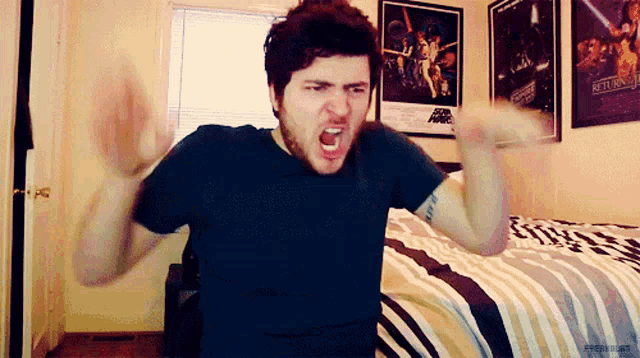 a man is screaming in front of a poster for the return of the jedi
