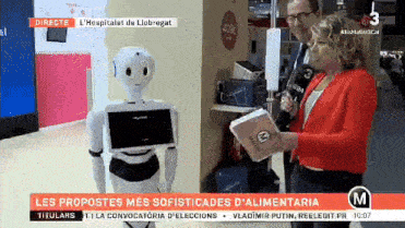 a woman in a red jacket is talking to a robot on a tv show