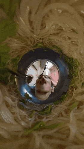 a person is looking through a hole in a bowl of noodles and vegetables