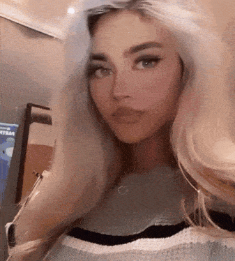 a woman with blonde hair is wearing a striped shirt