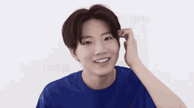 a young man wearing a blue shirt is smiling