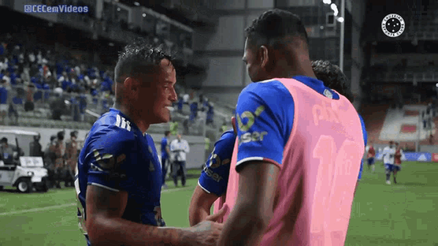 two soccer players are shaking hands on a field and the words cecemvideos are on the bottom
