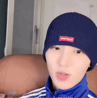 a young man wearing a blue beanie and a blue jacket .