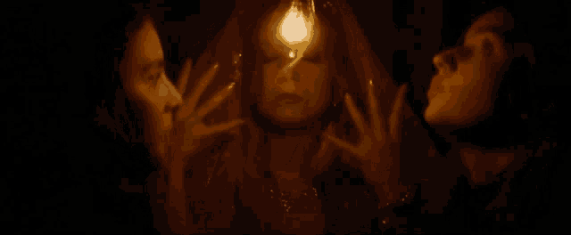 a woman covering her face with a veil is surrounded by two other women .