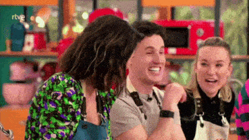 a group of people are laughing and one of them is wearing an apron with the word rtve on it