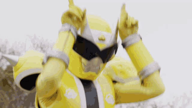 a yellow power ranger with his arms up