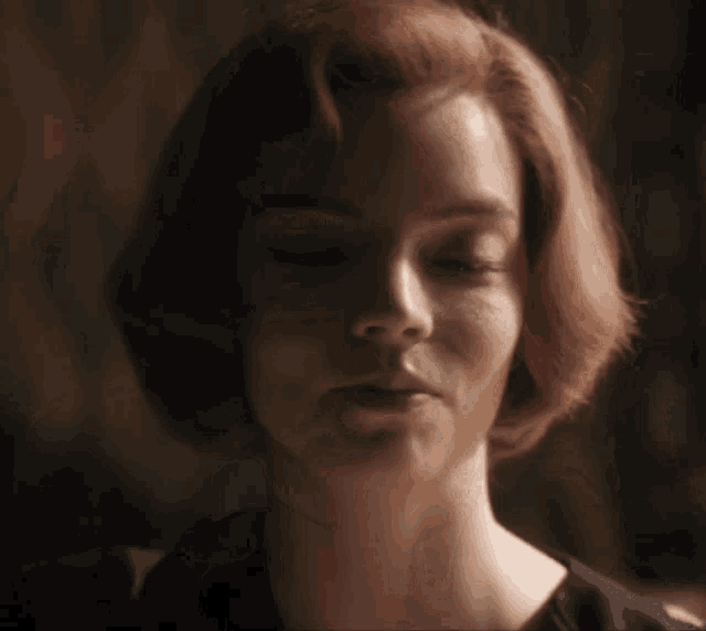 a woman with red hair is looking at the camera
