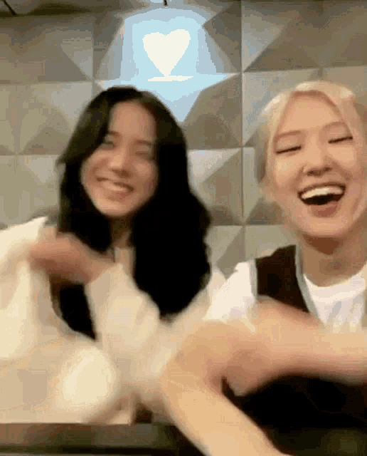 a couple of women are sitting next to each other laughing .