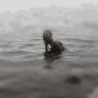 a woman in a bathing suit is swimming in the water