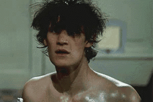 a shirtless man is brushing his teeth in a bathroom .