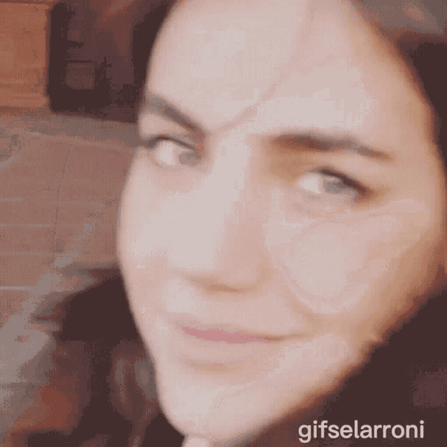a close up of a woman 's face with gifselarroni written below it