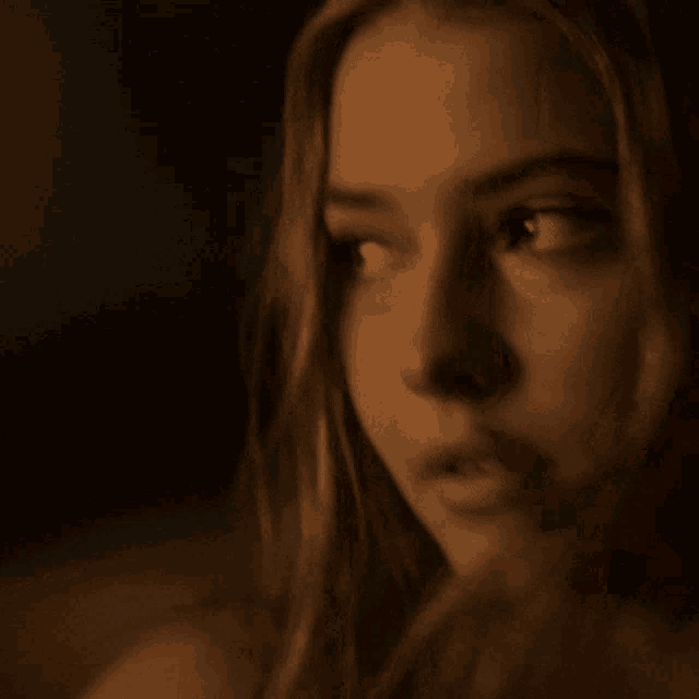 a close up of a woman 's face with her eyes looking at the camera