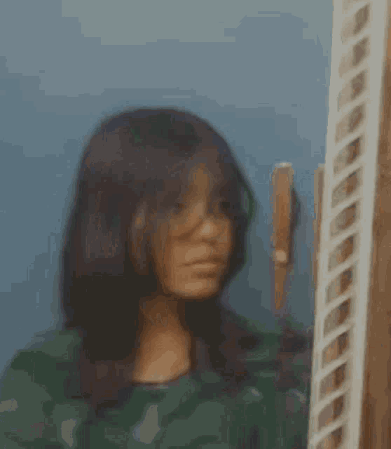 a woman is standing in front of a mirror looking at herself .