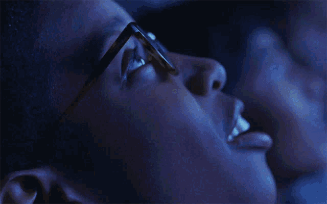 a close up of a person 's face wearing glasses