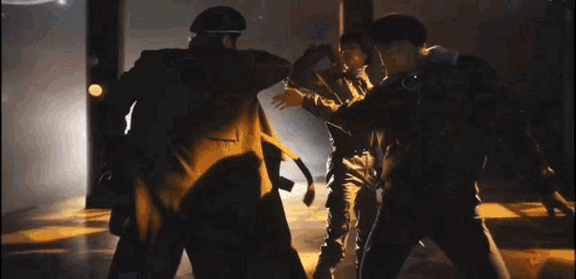 a group of people are standing next to each other in a dark room and giving each other a high five .