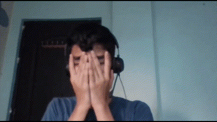 a man wearing headphones covering his eyes with his hands