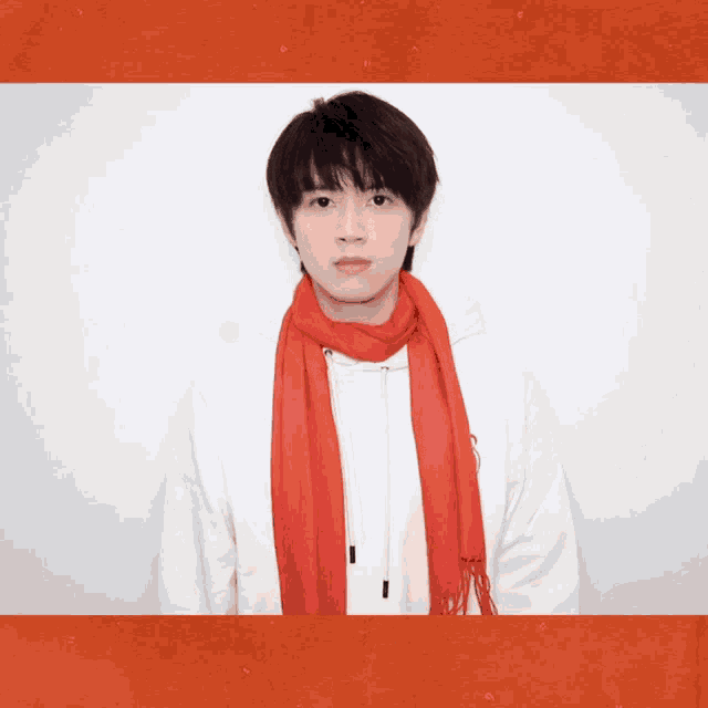 a young man wearing a white hoodie and a red scarf