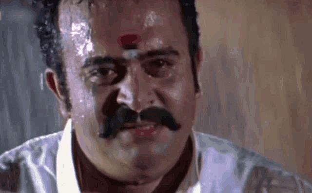 a man with a mustache and a white shirt is sweating .