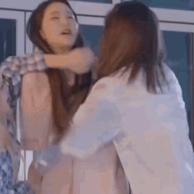two women are having a fight and one of them is holding the other woman 's neck .