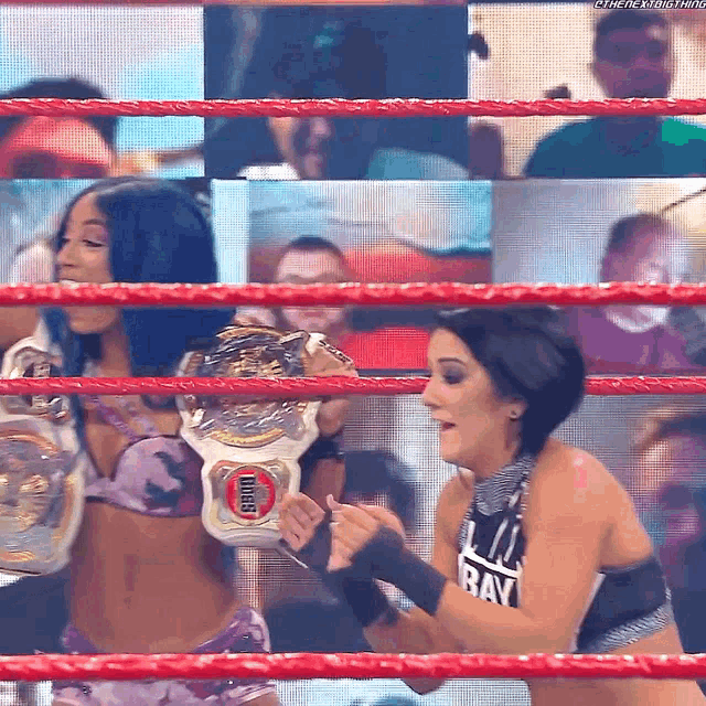 two women in a wrestling ring with one holding a belt that says intercontinental championship