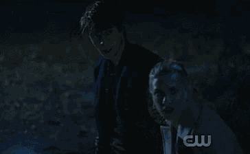 two people are standing next to each other in the dark .