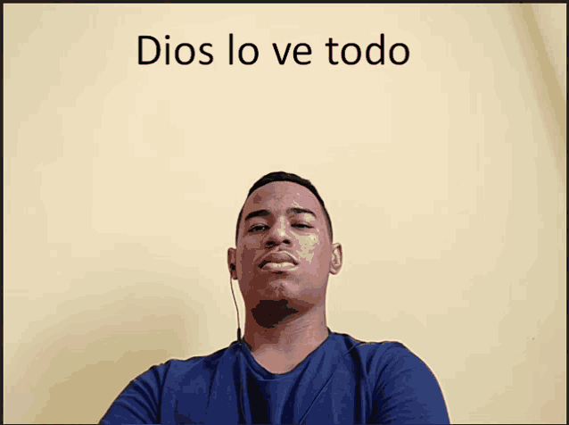 a man stands in front of a yellow wall with the words dios lo ve todo written above him