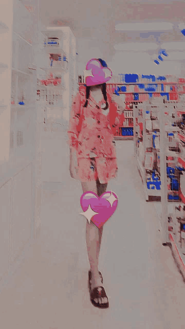 a woman in a pink dress is holding a pink heart on her leg