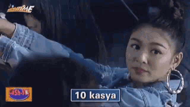 a woman is sitting in a car with a sign that says `` 10 kasya '' on it .
